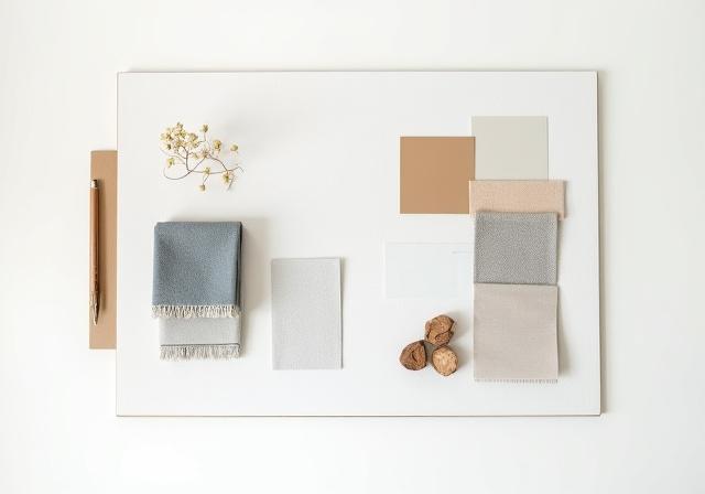 Mood board med tekstiler, fargestriper, og materialprøver